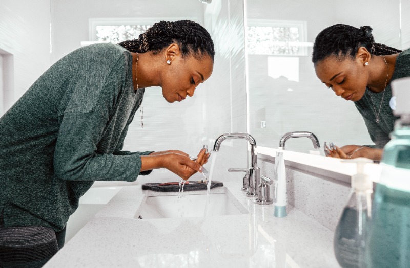 Woman washing her face with clean, soft water